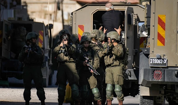 Israeli soldiers arrest a blindfolded Palestinian during an army raid in Tubas, West Bank, on Wednesday, Sept. 11, 2024. (AP Photo/Majdi Mohammed)