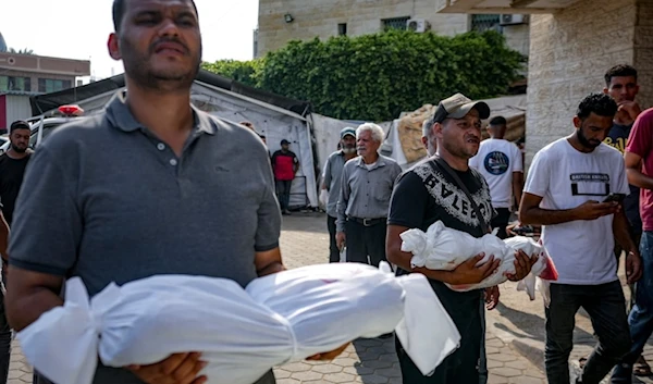 Palestinians hold the bodies of their relatives killed in the Israeli bombardment of the Gaza Strip, at a hospital in Deir al-Balah, on July 21, 2024. (AP)