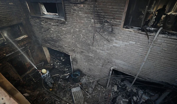 A firefighter hoses down a building hit in an Israeli airstrike in Damascus, Syria, Thursday, Nov. 14, 2024. (AP)