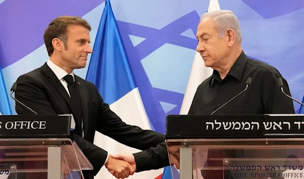 Israeli Prime Minister Benjamin Netanyahu, right, shakes hands with French President Emmanuel Macron during a joint press conference in occupied al-Quds, Oct. 24, 2023. (AP)