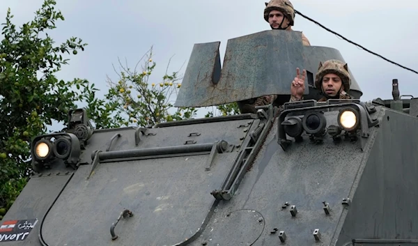 A Lebanese army soldier flashes victory sign, as a convoy enters in Mansouri village on its way to being deployed in southern Lebanon, following a ceasefire agreement in Lebanon, on Nov. 27, 2024.(AP)