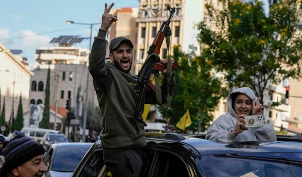 A Lebanese man carries an AK-47 as displaced people return to the Southern Suburb of Beirut, Lebanon, following a ceasefire between the Israeli occupation and Hezbollah that went into effect on Wednesday, November 27, 2024 (AP)