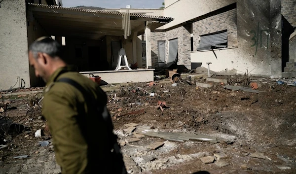 An Israeli occupation soldier inspects the site where a rocket fired from Lebanon landed in a backyard in Kiryat Shmona, northern occupied Palestine, on Nov. 26, 2024. (AP)