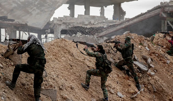 Syrian army soldiers fire their weapons during a battle with terrorist fighters at the Ramouseh front line, east of Aleppo, Syria, Dec. 5, 2016. (AP)