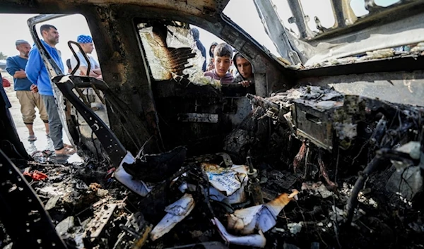 People inspect the site where World Central Kitchen workers were killed in Deir al-Balah, Gaza Strip, Tuesday, April 2, 2024. (AP)