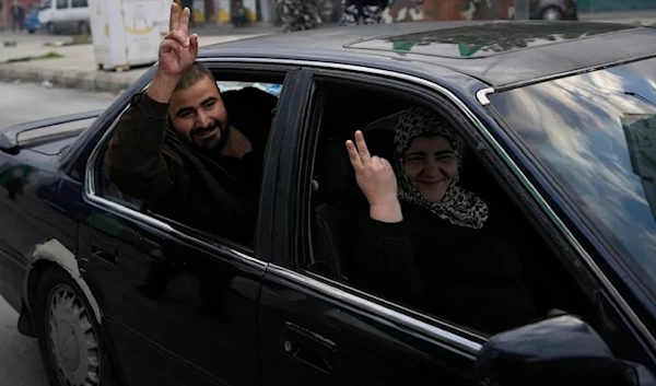 People flash victory signs as they return to their villages in Tyre. (AP)