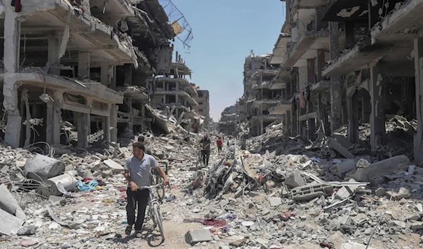 Palestinians walk through the destruction in the wake of an Israeli air and ground offensive in Jabaliya, northern Gaza Strip, May 30, 2024. (AP)