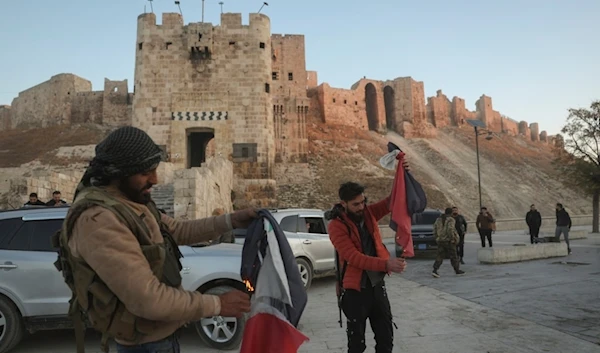 Syrian terrorists burn government Syrian flags for the cameras next to Aleppo's old city, Saturday, Nov. 30, 2024 (AP)