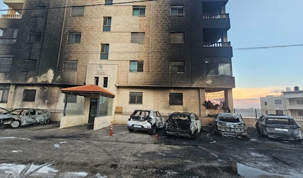 Palestinian vehicles and the front of a residential building burned by Israeli settlers during an attack on al-Bireh and Deir Dibwan, November 4, 2024 (Social Media)