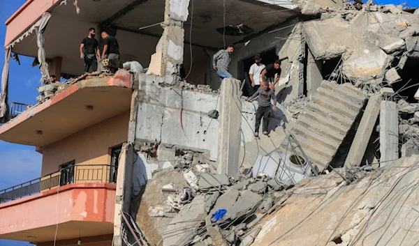 People search for victims at a destroyed building hit in an Israeli airstrike, in Ghaziyeh town, south Lebanon, Sunday, Nov. 3, 2024. (AP Photo/Mohammed Zaatari)