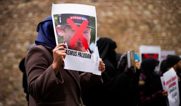 A woman holds a photograph of far-right activist Rasmus Paludan during a small protest outside the Swedish consulate in Istanbul, Turkey, Saturday, Jan. 28, 2023. (AP)