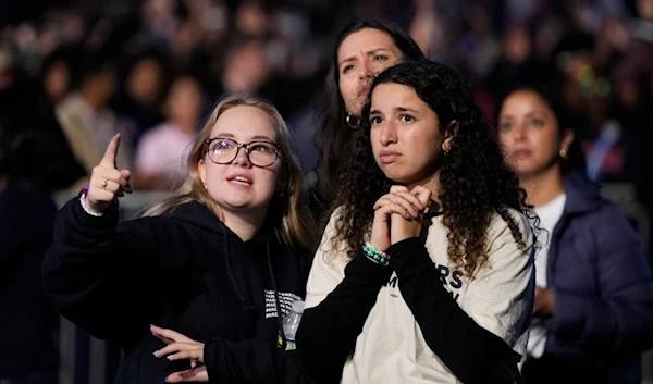 Supporters of Democratic presidential nominee Vice President Kamala Harris look at election results during an election night campaign watch party Tuesday, November 5, 2024, on the campus of Howard University in Washington (AP)