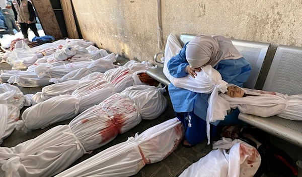 A Palestinian woman reacts over the body of a child as she sits by bodies of Palestinians killed by Israeli airstrikes on Jabalia refugee camp, at the Indonesian hospital, northern Gaza Strip, Nov. 18, 2023. (AP)