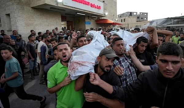 Palestinians mourn as they carry the bodies of relatives killed in the Israeli bombardment of the Gaza Strip at a hospital in Deir el-Balah, Sunday, Oct. 20, 2024 (AP)