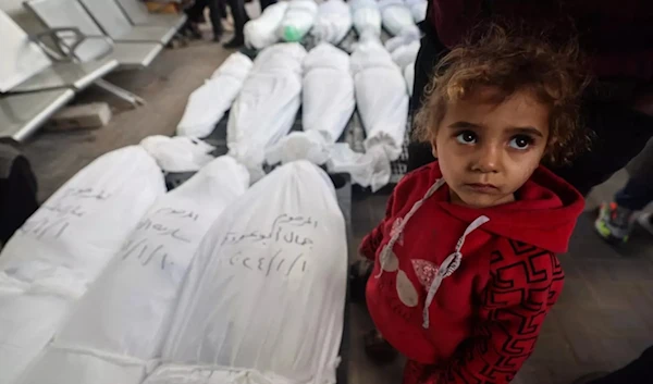 A child stands next to the bodies of family members after they were killed during Israeli bombardment, on January 10, 2024, in Rafah in the Gaza Strip. (AFP)