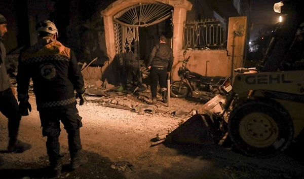 Residents inspect the site of an air strike in Idlib, Syria, Sunday, December 1, 2024 (AP)