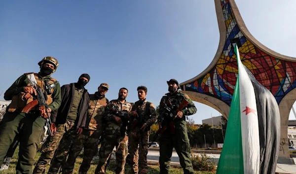 Syrian opposition fighters pose for a photograph as they celebrate at Umayyad Square in Damascus, Syria, Monday, Dec. 9, 2024. (AP)