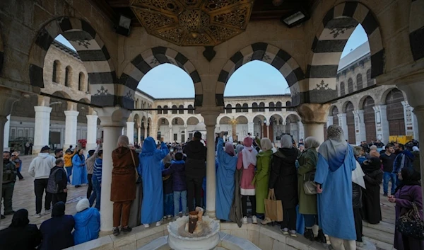 People watch and take photos with their cell phones as new regime supporters celebrate in the courtyard of the Umayyad Mosque in the old walled city of Damascus, Syria, on Tuesday, December 10, 2024 (AP)