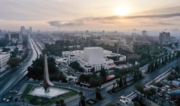 An aerial view shows a column of black smoke in the background, caused by an Israeli airstrike, as seen from Umayyad Square in Damascus, Syria, Tuesday, December 10, 2024 (AP)