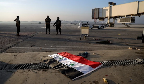 Syrian opposition fighters stand atop a seized Syrian Air Force fighter plane at the Hama military airport, Syria, Friday Dec. 6, 2024. (AP)