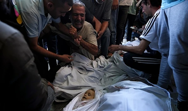 Palestinians mourn for relatives killed in the Israeli bombardment of the Gaza strip at a hospital morgue in Deir al-Balah in October 2024. (AP)