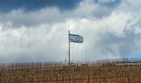 An Israeli flag waves on the top of a hill near the Alpha Line that separates the occupied Golan Heights from Syria, in the town of Majdal Shams, Friday, Dec. 13, 2024. (AP)