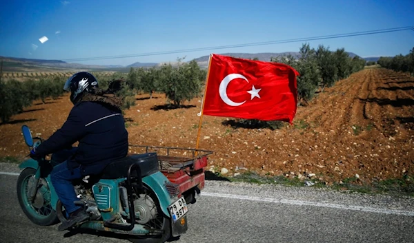 A Turkish motorcyclist drives on the outskirts of the border town of Kilis, Turkey, in support of Turkish troops, Tuesday, Jan. 30, 2018. (AP)