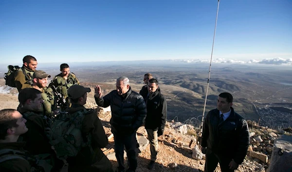 Israeli Prime Minister Benjamin Netanyahu, center, talks with Israeli soldiers at a military outpost during a visit at Mount Hermon in the occupied Golan Heights overlooking the Palestine-Syria border on Feb. 4, 2015. (AP)