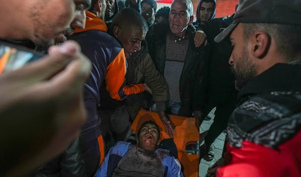 An injured man is carried into the Al-Aqsa Martyrs hospital in Deir al-Balah after an Israeli army strike in the Bureij refugee camp, central Gaza Strip, on December 14, 2024. (AP)