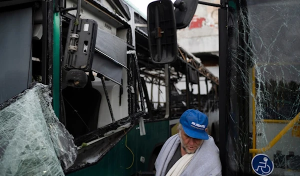 A man checks the buses that were damaged following a rocket attack fired from Lebanon during the night, hours before the start of the ceasefire, in Kiryat Shmona, northern Palestine, Nov. 27, 2024. (AP)