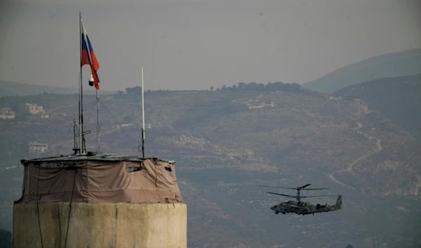 A Russian helicopter flies over the Hmeimim Air Base, a Syrian airbase currently operated by Russia, located southeast of the city of Latakia in the town of Hmeimim, Syria, on Monday, December 16, 2024 (AP)