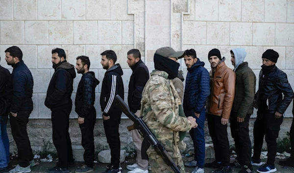 Members from the Syrian Arab Army line up to register with Syrian rebels as part of an "identification and reconciliation process" at an army compound in Latakia, Syria, Tuesday, December 17, 2024 (AP)