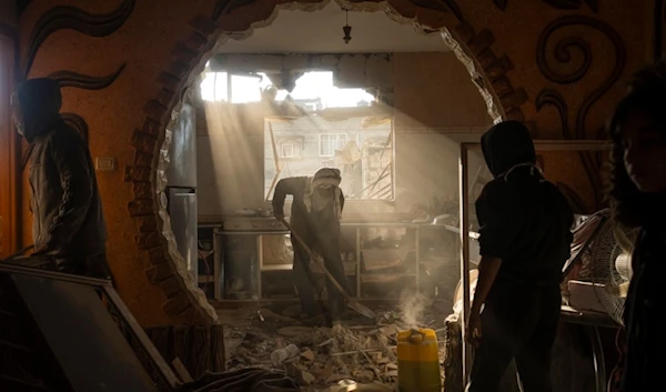 Palestinians look at their neighbor's damaged house following an Israeli strike in Rafah, southern Gaza Strip, January 27, 2024 (AP)