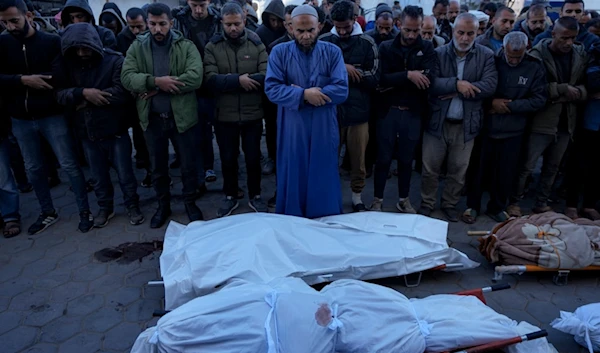 Palestinians pray next to the bodies of their relatives killed in the Israeli bombardment of the Gaza Strip, at a hospital in Deir al-Balah, Sunday, Dec. 15, 2024. (AP)