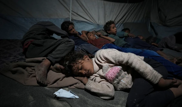 Shireen Daifallah's children, who were displaced from northern Gaza, sleep in their tent at a camp for displaced people in Deir al-Balah. Gaza Strip, on November 30, 2024. (AP)