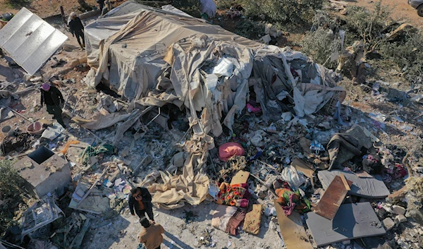 People inspects a camp for internally displaced people destroyed during an airstrike near the village of Harbnush, north of Idlib, Syria, on December 2, 2024. (AP)