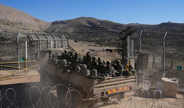 Israeli soldiers stand on an armoured vehicles before crossing the security fence, moving towards the so-called Alpha Line that separates the Israeli-controlled Golan Heights from Syria, in the town of Majdal Shams, on December 18, 2024. (AP)