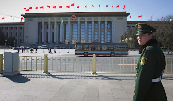 A paramilitary police officer stands guard in Tiananmen Square with the Great Hall of the People in the background in Beijing, Tuesday, March 1, 2011.