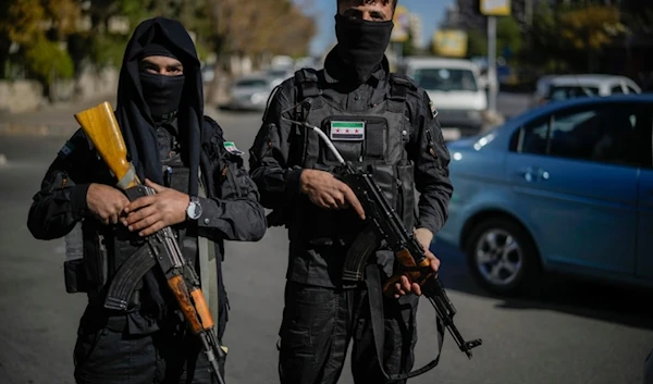 Two Syrian fighters pose for the photographer as they patrol in downtown Damascus, Syria, Dec. 19, 2024. (AP)