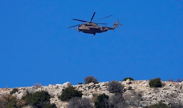 An Israeli occupation Air Force Black Hawk helicopter flies over Mount Hermon near the so-called Alpha Line that separates the Israeli-occupied Golan Heights from Syria, Dec. 17, 2024. (AP)