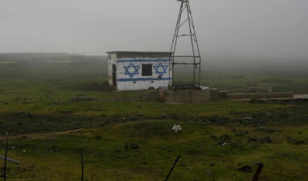 A house painted with the colors of the Israeli flag is seen next to a road in the Israeli-controlled Golan Heights, on a foggy Sunday, Dec. 22, 2024. (AP Photo/Matias Delacroix)