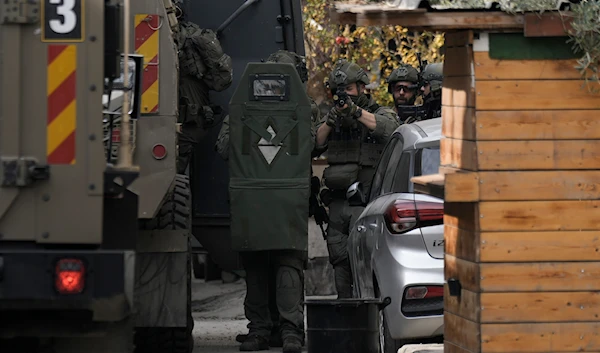 Israeli soldiers are seen during an army raid, following a car that was hit by bullets in which a Palestinian was reportedly killed by Israeli special force, in the occupied West Bank city of Qalqilya, on December 12, 2024. (AP)