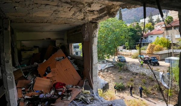 Israeli occupation settlers stand next to the site where a rocket fired from Lebanon hit a residential building in Kiryat Shmona, in northern occupied Palestine, Nov. 20, 2024. (AP)