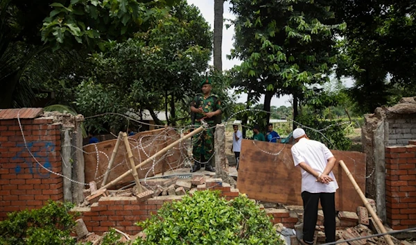 A man peeks inside the boundary wall of the vandalised house of Sheikh Hasina, who resigned as Prime Minister on Monday, in Dhaka, Bangladesh, Tuesday, Aug. 6, 2024. (AP)