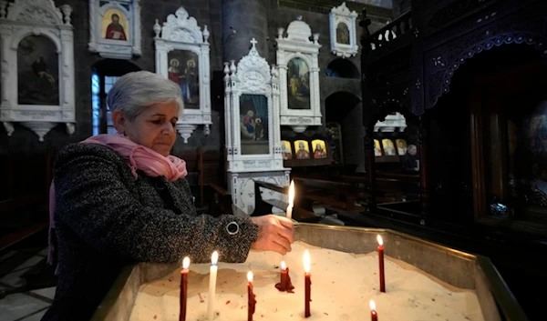 A Syrian woman lights a candle inside a church during the first Sunday Mass since Syrian President Bashar Assad's ouster, in old Damascus, Syria, Sunday, Dec. 15, 2024. (AP)