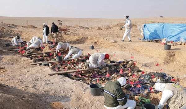 Crime scene investigators remove human remains from a mass grave in Al Muthana province, believed to be those of Kurds killed in a Saddam Hussein government crackdown on the group in 1987-1988. (Iraqi President Office)