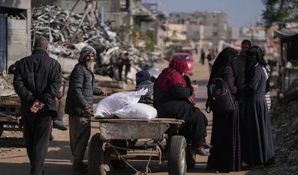 Palestinians carry UN donated flour in Khan Younis, central Gaza Strip, on December 14, 2024.(AP )