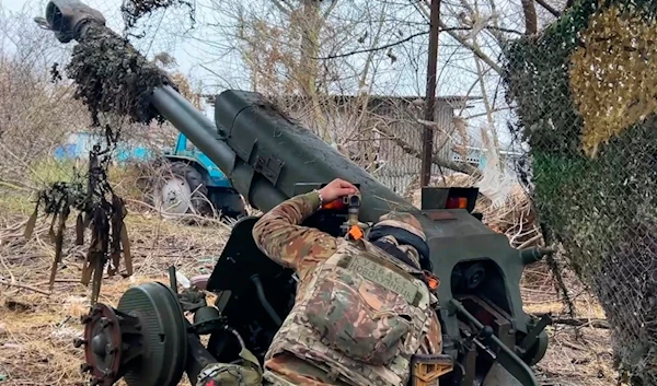 In this photo taken from a video released by the Russian Defense Ministry press service on Friday, November 29, 2024, a Russian serviceman aims a D-30 howitzer toward Ukrainian positions in the border area of Kursk region, Russia (AP)