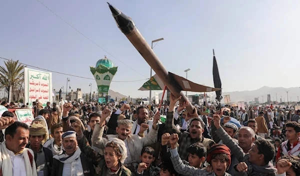 Yemeni demonstrators carry a mock rocket and chant slogans during an anti-Israeli occupation rally in Sanaa, Yemen, Friday, Dec. 27, 2024 (AP)