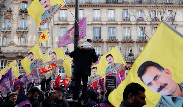 Kurdish activists hold a posters of jailed PKK leader Abdullah Ocalan during a protest in Paris, Saturday, Jan. 7, 2023. (AP)